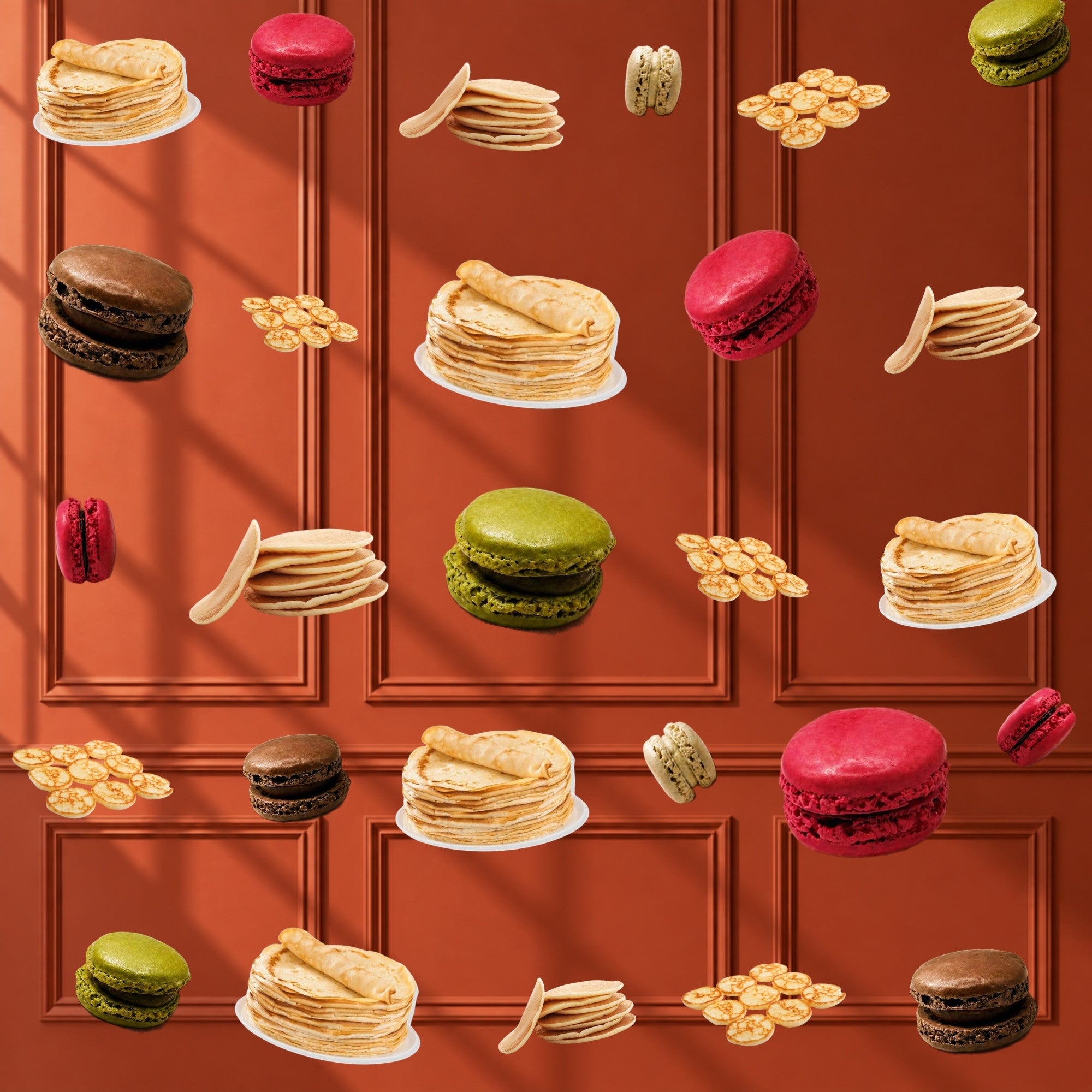 French crêpes, pancakes, mini blinis and macarons falling against a terracotta wall